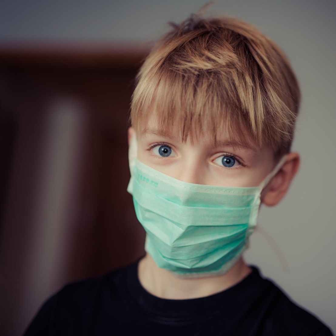 Kid with a medical mask on looking into the camera. Photo by Janko Ferlic on Pexels.com